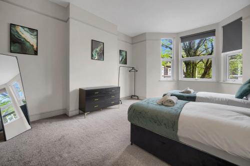 1 dormitorio con 2 camas, vestidor y ventanas en Free Parking Fast Wifi 2 Min to Cardiff City, en Cardiff