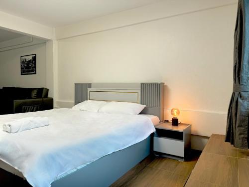 a bedroom with a large white bed and a chair at Berlin Haus in Nonthaburi