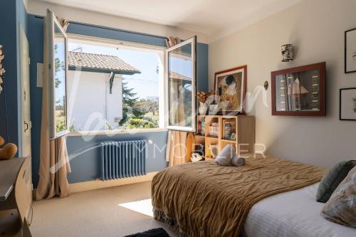 une chambre avec un lit et une grande fenêtre dans l'établissement Villa Silvana, à Anglet
