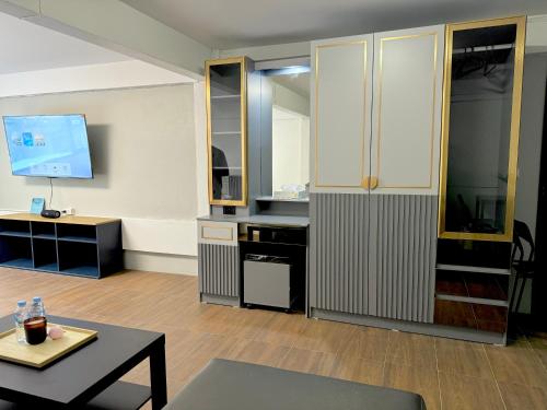 a living room with a table and a tv at Berlin Haus in Nonthaburi