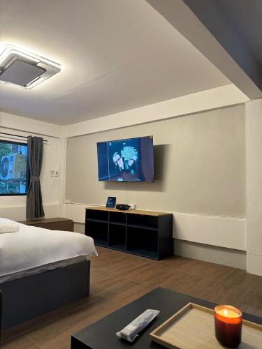 a bedroom with a bed and a tv on a wall at Berlin Haus in Nonthaburi