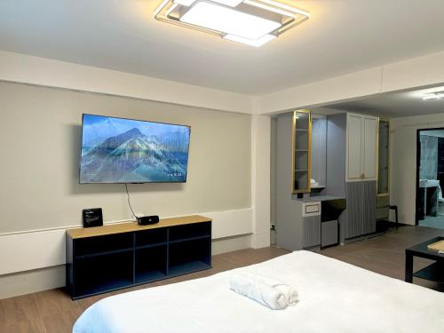 a bedroom with a bed and a television on the wall at Berlin Haus in Nonthaburi