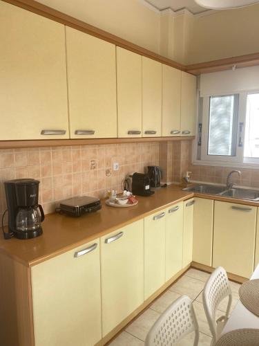 a kitchen with white cabinets and a sink at Nan Apart 2, Salamina in Paloúkia