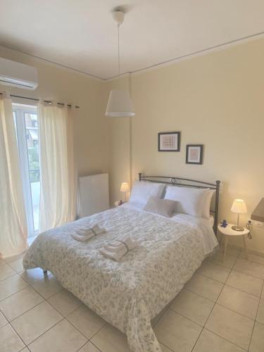 a bedroom with a large bed with two towels on it at Nan Apart 2, Salamina in Paloúkia
