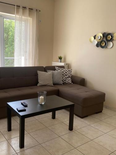 a living room with a brown couch and a coffee table at Nan Apart 2, Salamina in Paloúkia