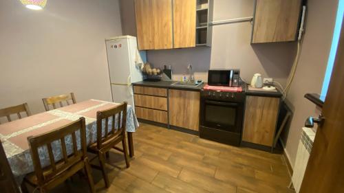 a kitchen with a table and a stove and a refrigerator at Квартира в центре города in Umanʼ