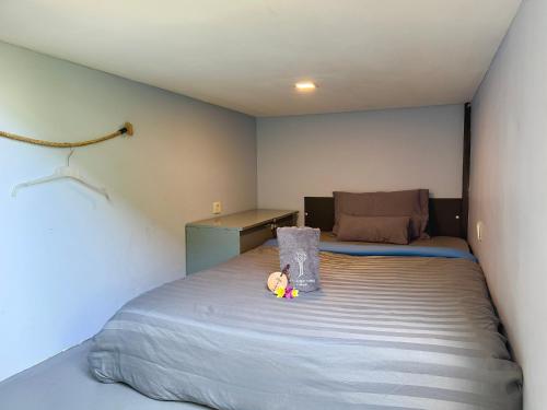 a bedroom with a bed with a teddy bear on it at The Jungle Hostel Canggu in Canggu