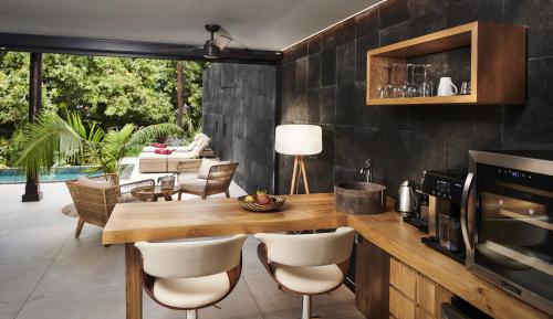a kitchen with a wooden counter and chairs and a table at Palm Hotel & Spa in Petite Île