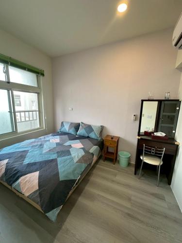 a bedroom with a bed and a desk and a mirror at 小琉球觀海洋客棧View Ocean Inn in Xiaoliuqiu