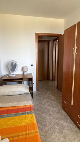 a bedroom with a bed and a desk with a fan at L'Alba in Tropea