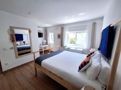 a bedroom with a large bed and a window at Romantik Villa in Salema
