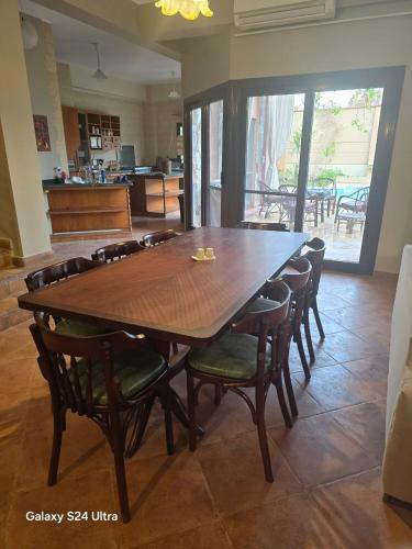 a large wooden table and chairs in a room at Bahga villa in Alexandria