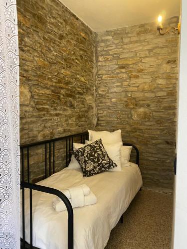 a bed in a room with a stone wall at La Lupa e l'Orso in Berceto