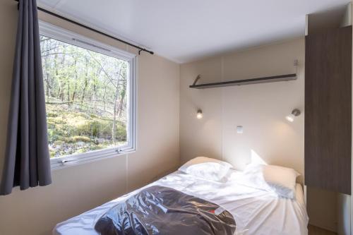 une chambre avec un lit et une fenêtre dans l'établissement Mobilhome O’Hara 734T, à Bouzic