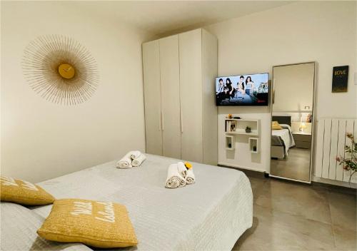 a bedroom with two beds and a flat screen tv at La Collina di Montegrappa - Suites with Heated Private Pool - Suites with Shared Pool in Tuglie