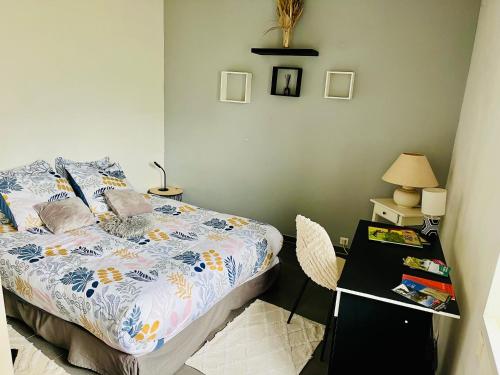 a bedroom with a bed and a table with a lamp at Maison entre Saumur et Montreuil Bellay La Motte in Artannes-sur-Thouet