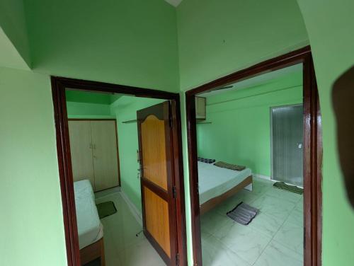 a small bedroom with a bed and a mirror at Elite rooms in Tiruvannāmalai