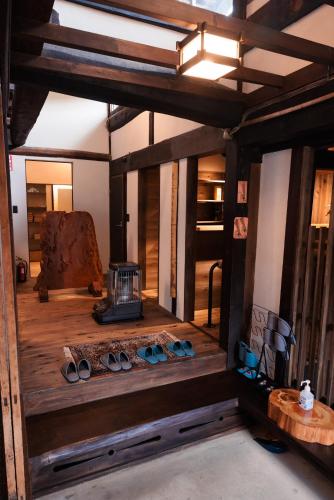 an inside view of a room with wooden floors and a stove at 古民家一棟貸し有山 in Nakatsugawa