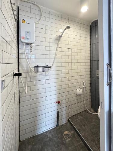 a bathroom with a shower with white tile walls at Chubby 9 in Bang O