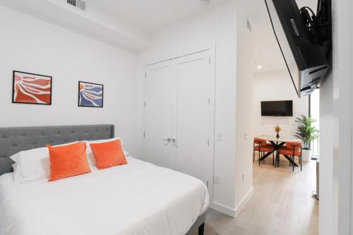 a bedroom with a bed with orange pillows and a desk at Unit 4 Studio Queen plus Sofa Bed DC Convention Centre in Washington, D.C.