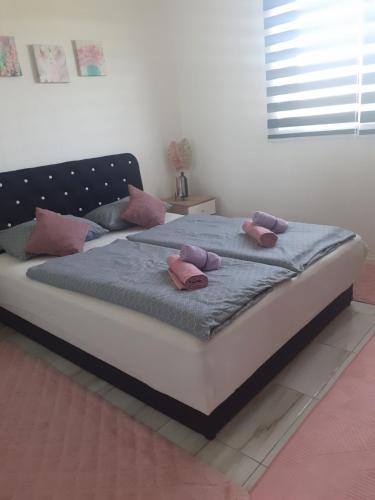 a bed with pink pillows on it in a room at Apartman Cirkic in Sanski most