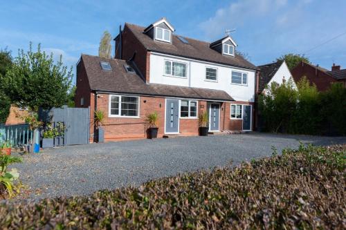 a house with a driveway in front of it at Bridge House Apartments - Free Parking in Shottery