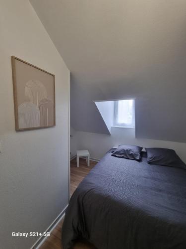 une chambre avec un lit et un tableau au mur dans l'établissement Le Belfort centre ville, à Chalon-sur-Saône