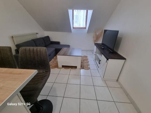 a living room with a couch and a tv at Le Belfort centre ville in Chalon-sur-Saône