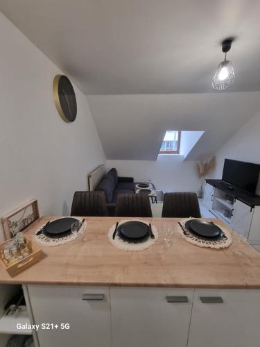 Cette chambre comprend une table avec des chaises et un piano. dans l'établissement Le Belfort centre ville, à Chalon-sur-Saône