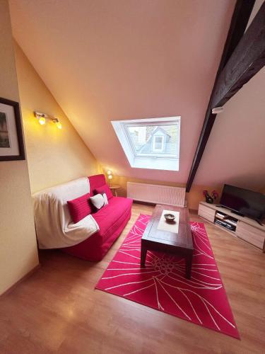 - un salon avec un canapé rouge et une fenêtre dans l'établissement Au fil du temps, à Morlaix