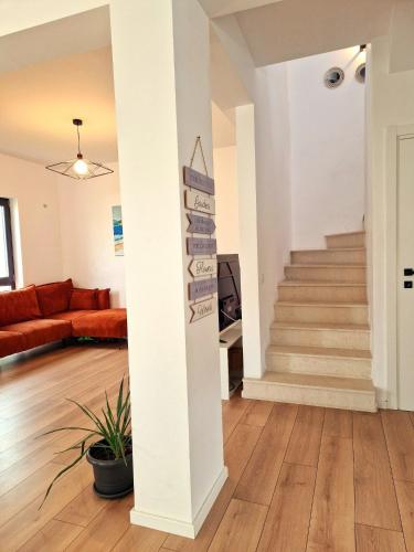 a living room with a staircase and a couch at Dalia-Serenity next to Therme in Baloteşti
