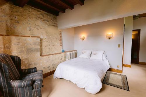 une chambre avec un lit blanc et une chaise dans l'établissement Remarkable renovated castle, à Villeneuve-sur-Lot