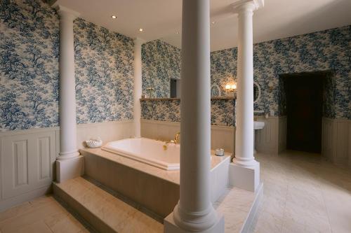 La grande salle de bains est pourvue d'une baignoire et de colonnes. dans l'établissement Remarkable renovated castle, à Villeneuve-sur-Lot