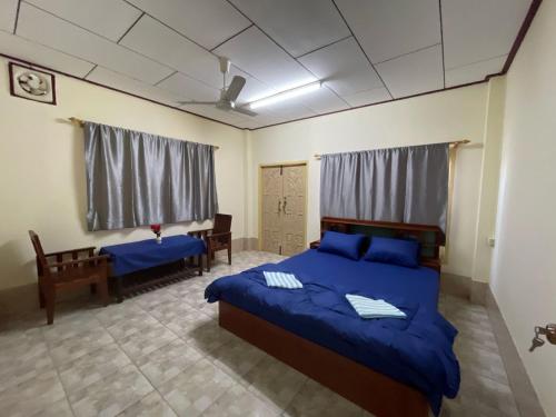 a bedroom with a blue bed and a desk at Catty tourist house in Thakhek
