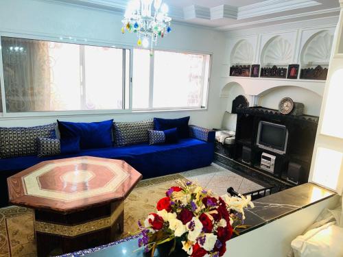 un salon avec un canapé bleu et une table dans l'établissement Les 3 SOEURS MAJORELLE, à Marrakech