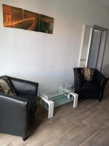 a living room with two chairs and a glass table at Ibis Tourist Residence 1 in Mahébourg