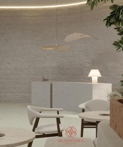 a living room with white chairs and a table at Hotel Skanderbeg in Golem