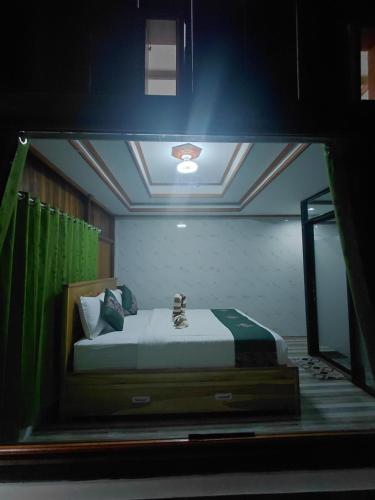 a bedroom with a bed in a glass window at Friendly Homestay Lemukih in Singaraja