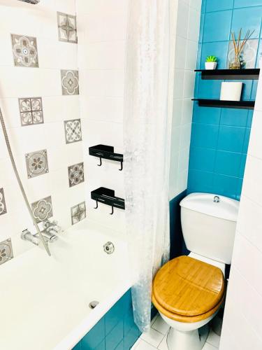 La salle de bains est pourvue de toilettes et d'une baignoire avec un siège en bois. dans l'établissement Charmant studio Morzine Centre, à Morzine