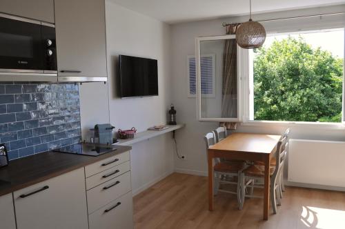 une cuisine avec une petite table et une fenêtre dans l'établissement Villers very center, sea view - Private parking, à Villers-sur-Mer