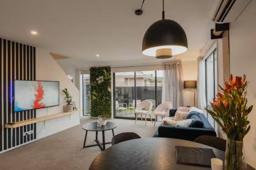 a living room with a couch and a table at Travellers' dream steps from shops and close to Airport in Christchurch