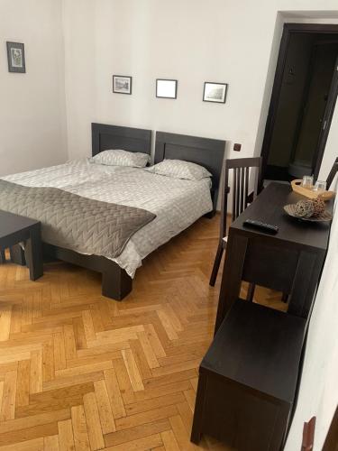 a bedroom with a bed and a table and a desk at Rami House central double rooms in Braşov