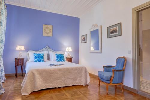 a bedroom with a bed and two blue chairs at IPEKYOL Guesthouse in Çeşme