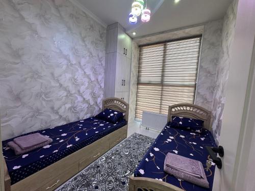 a bedroom with two beds and a window at ONE GLOBAL FAMILY GUEST HOUSE SAMARKAND lll in Samarkand