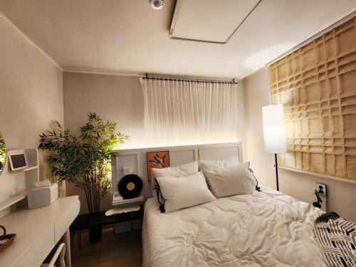 a bedroom with a white bed and a window at YNNY stay#Yeongdeungpo#Yeouido#7-8 minutes walk from Daebang Station-Line1 and Singil Station-Line1,5 in Seoul