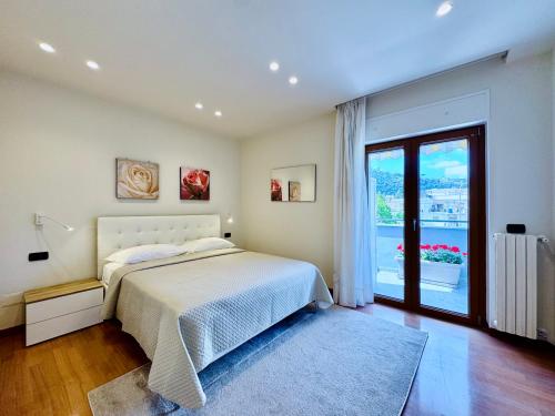 YourHome - A Casa di Manuela في سانتّانييلّو: غرفة نوم بها سرير ونافذة كبيرة