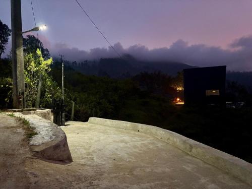 a bench with a view of a mountain at night at The ZenDen in Lindula