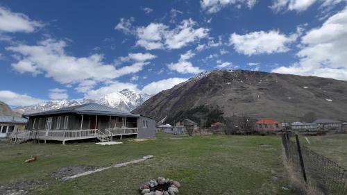 a house in a field with a mountain in the background at Family house in Ach'khoti
