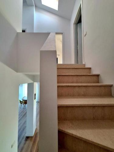 a staircase in a house with a view of a table at Dalia-Serenity next to Therme in Baloteşti