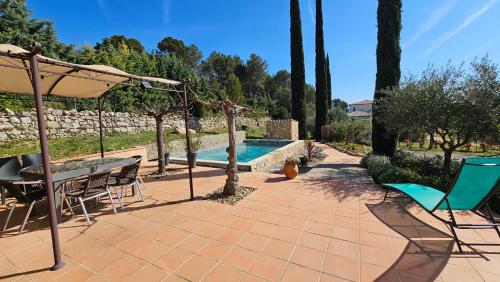 a patio with a table and chairs and a pool at Aux trois Cyprès Salernes en Provence in Salernes